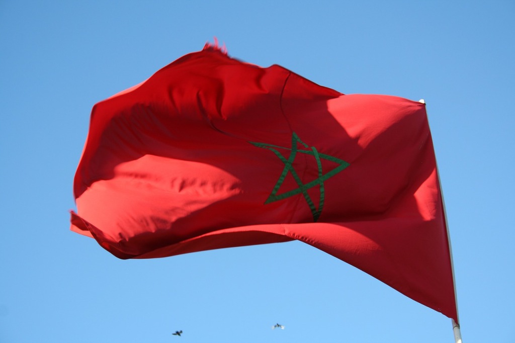Man sieht die marokkanische Flagge. Diese ist vollständig rot mit einem grünen Stern in der Mitte.